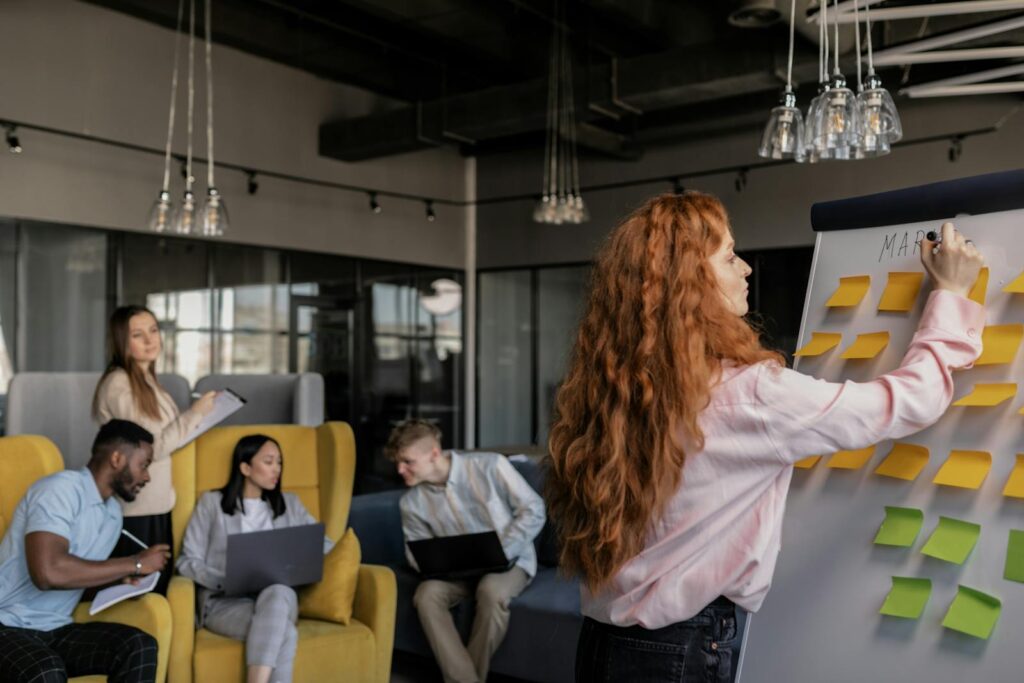 Team members collaborating in a modern office, focusing on strategy and planning using sticky notes.